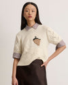 Cream Baxter Sweater with swan design on a model, featuring cable knit pattern and short sleeves.